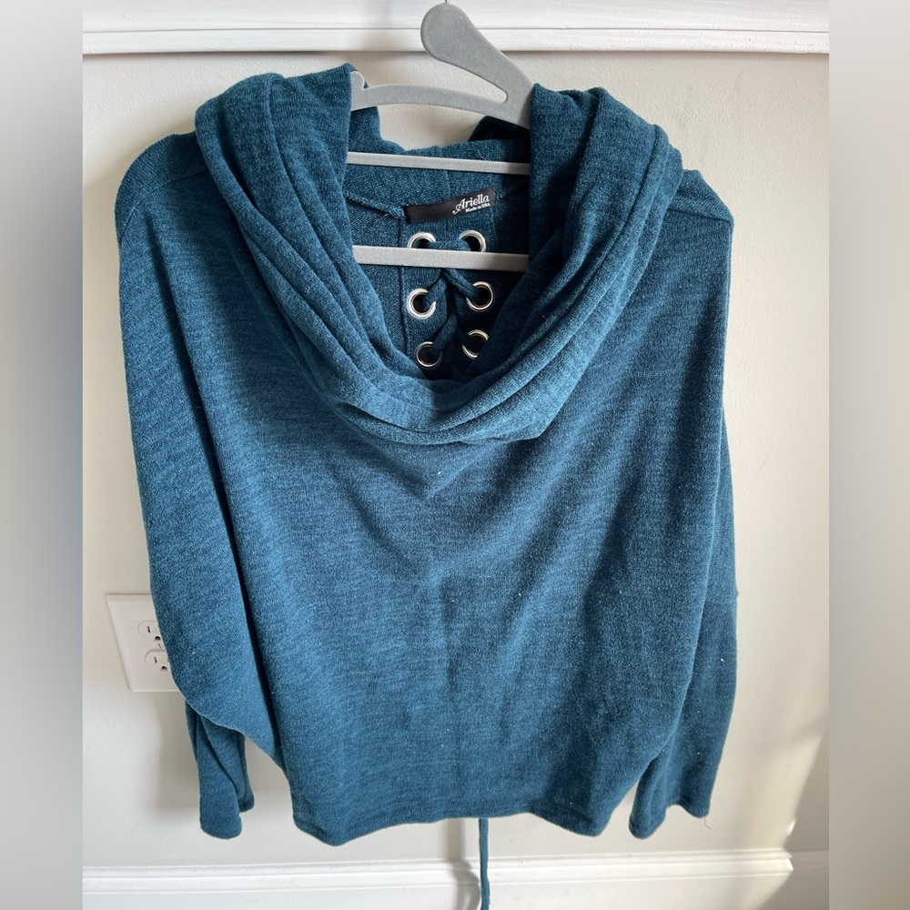 Turquoise sweater with a loose turtle beach. Tie up back.